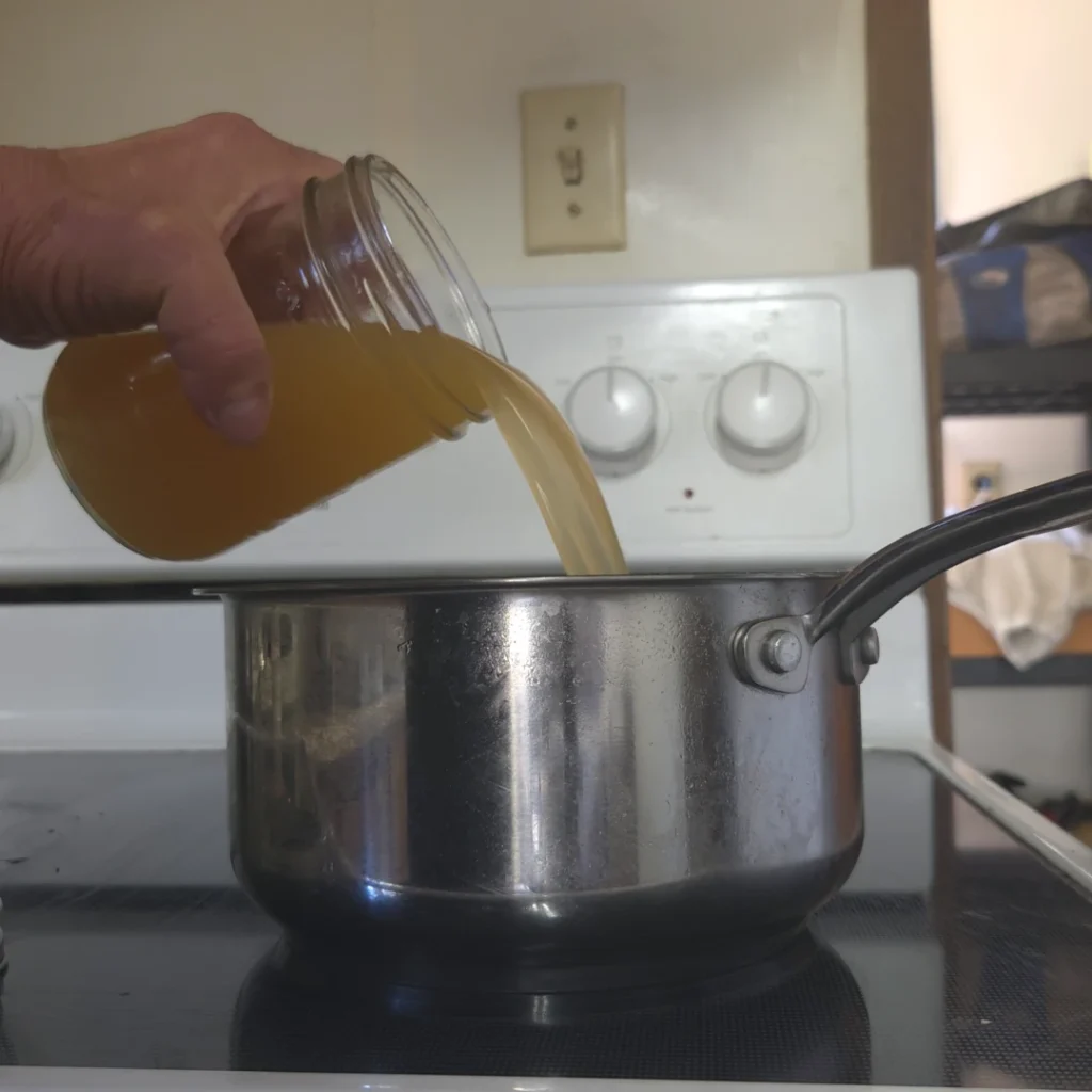 Pouring homemade stock int a pot