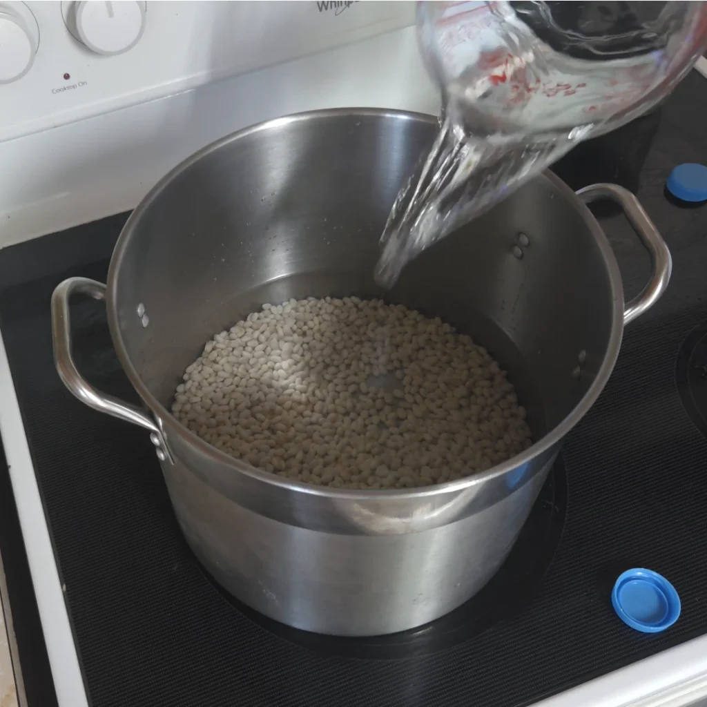Adding water to dry beans for soaking