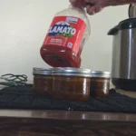 Jar of Clamato juice above canned moose