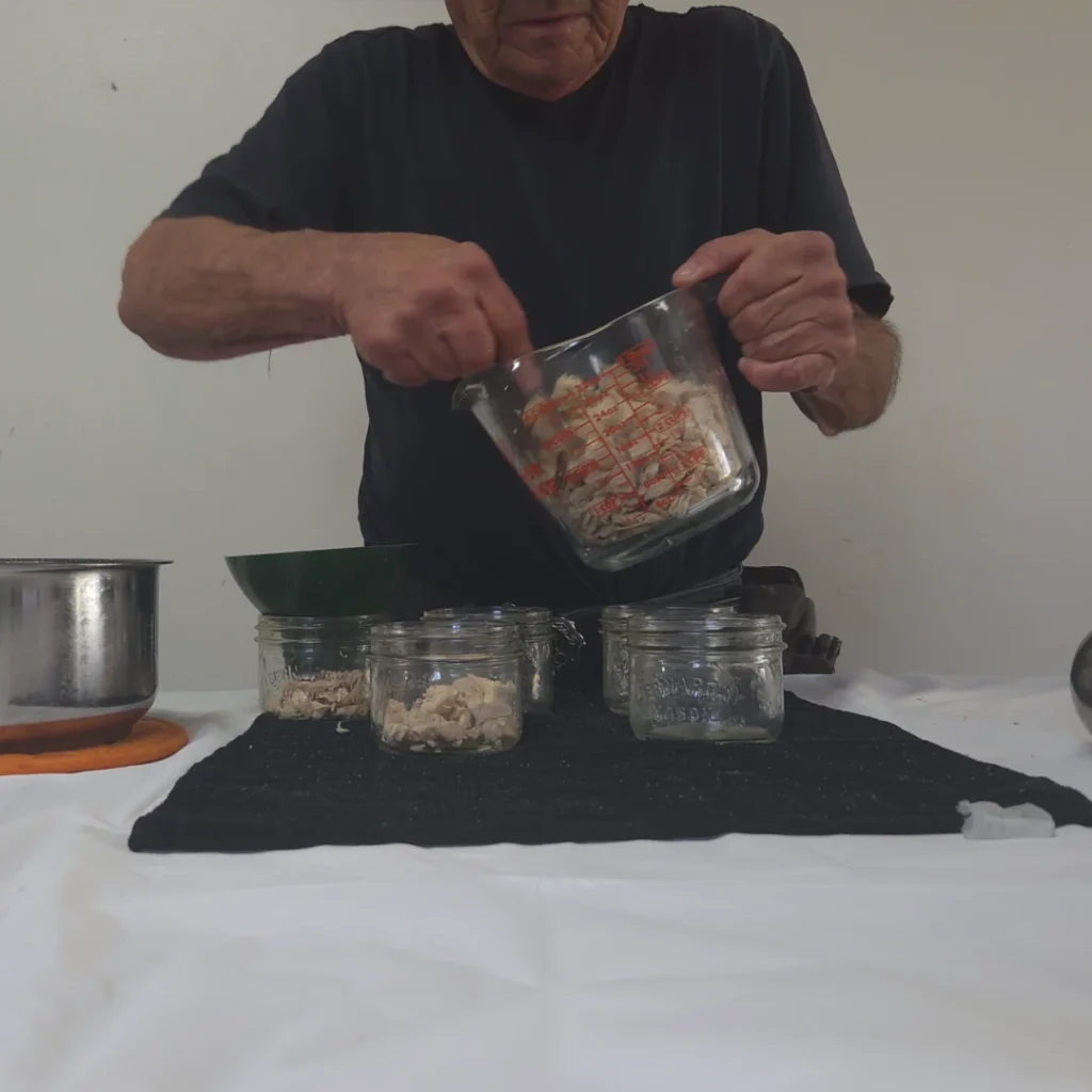 Filling the jars with chicken