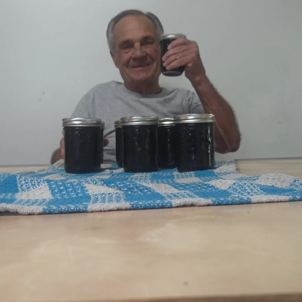 Holding a jar of finished Haskap jam
