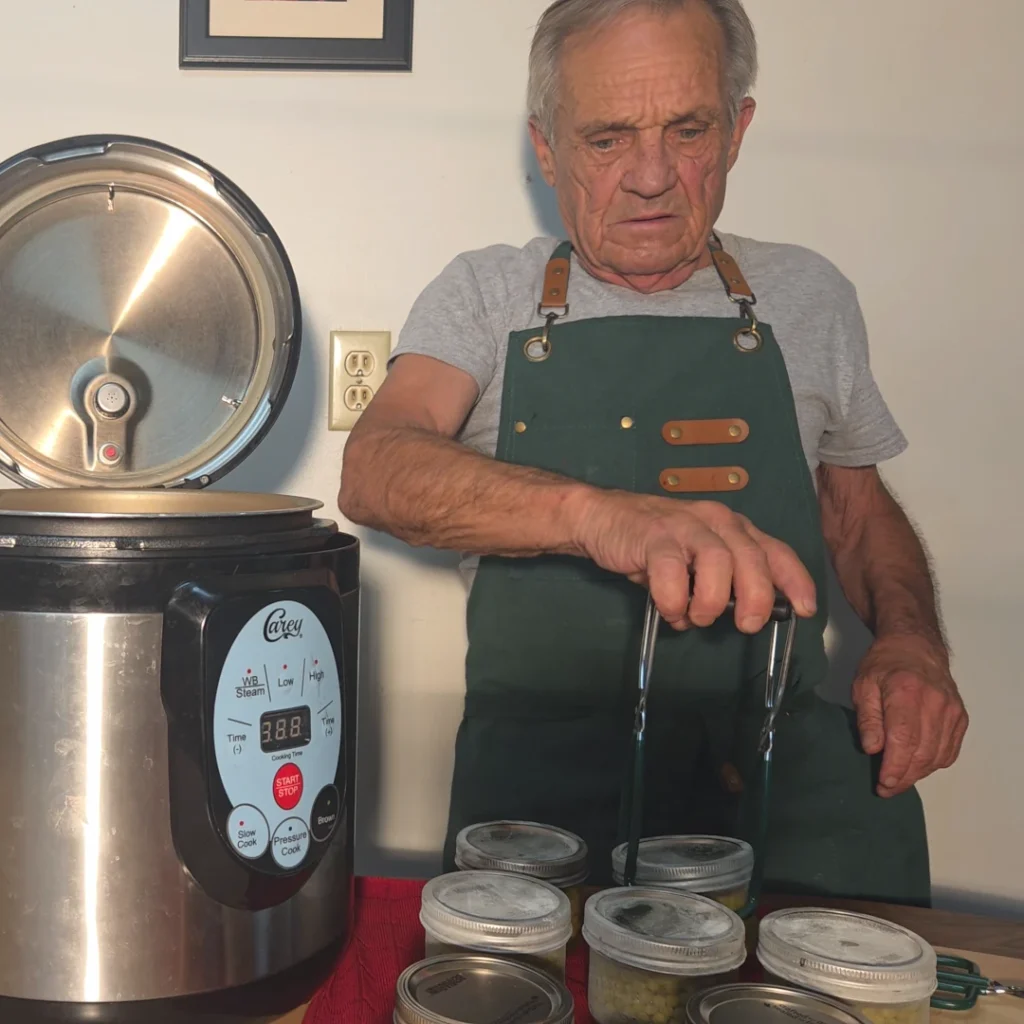 Pulling the jars of canned peas from the canner