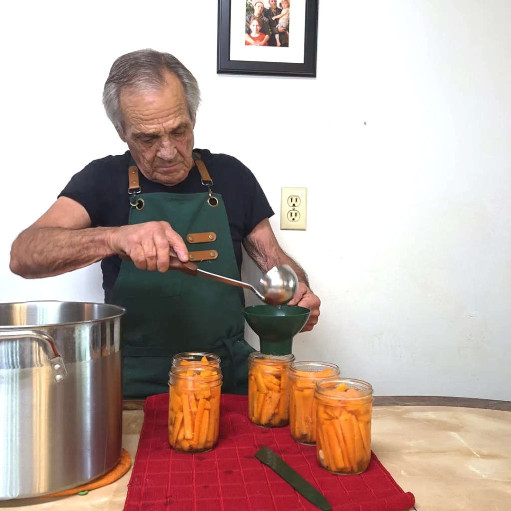 Ladling brine into the jars of carrots